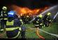 1_PHA_Požár haly v Uhříněvsi_pohled na hasiče, kteří několika vodními proudy hasí hořící objekt.JPG