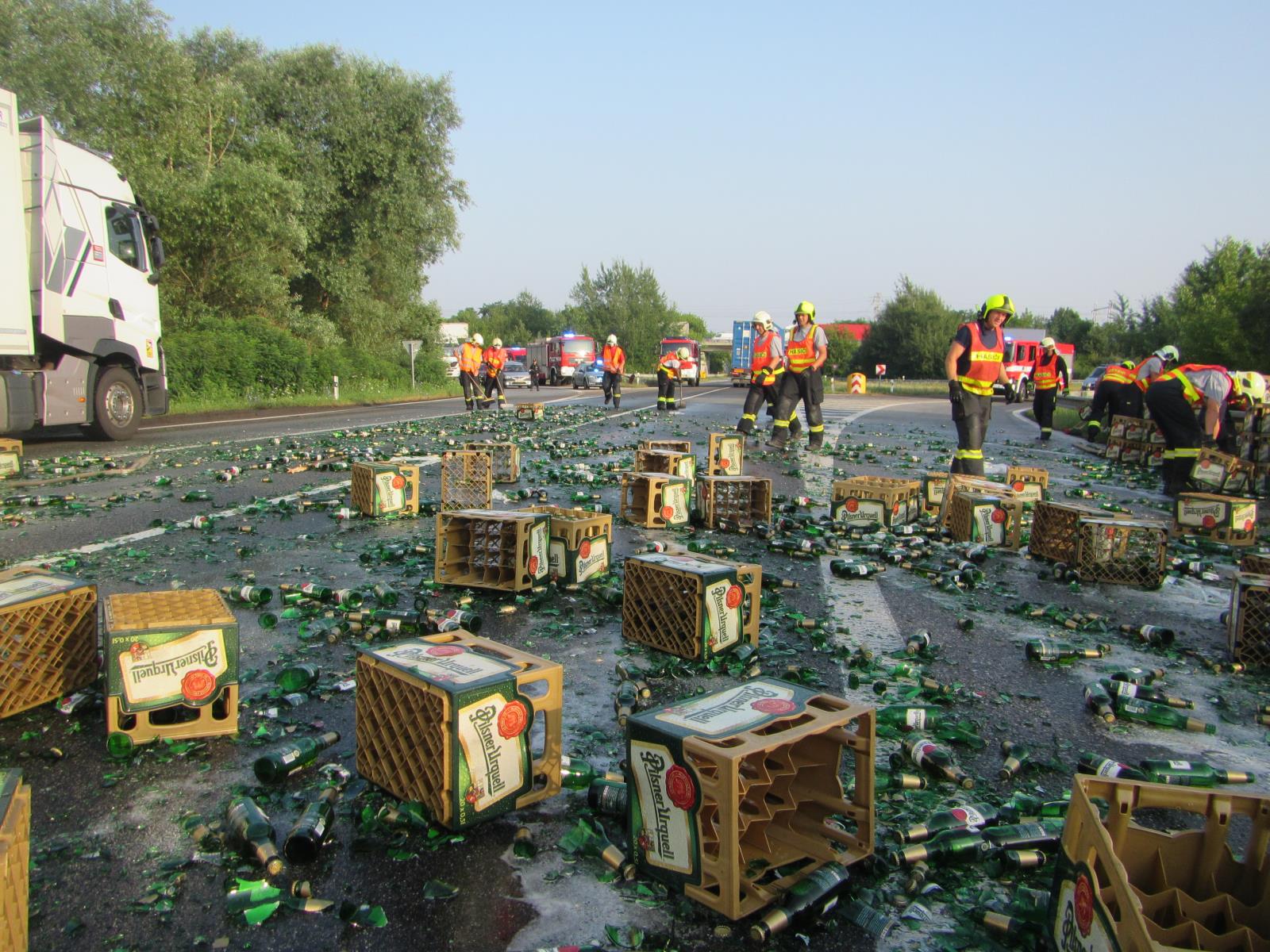 13_ZLK_Hasiči odklízejí ze silnice rozbité pivní lahve, které se vysypaly z kamionu.jpg