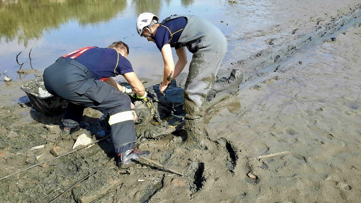 JMK_záchrana muže z vypuštěného rybníka_2 hasiči uvolňují lana muži, kterého přitáhli ke břehu.jpg