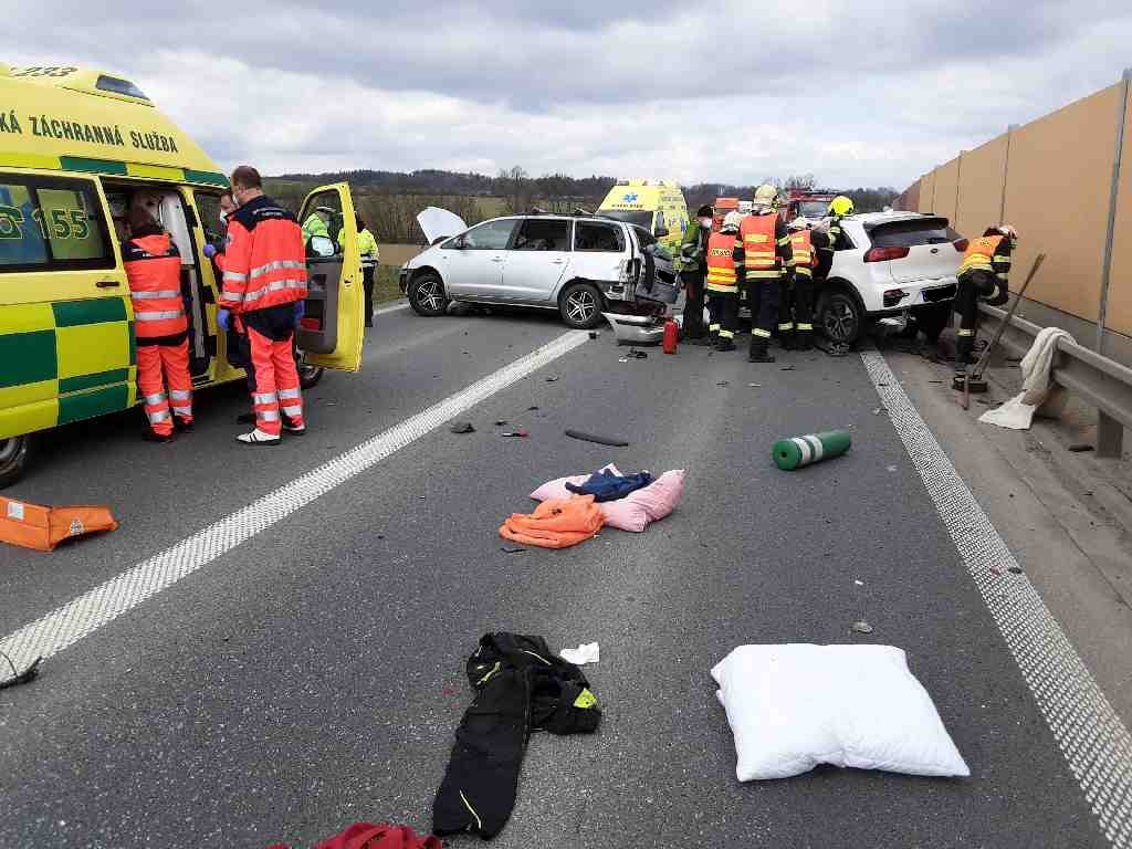 OLK_Hromadná DN 5 automobilů_pohled na havarované vozy, hasiče, záchranáře a poházené osobní věci cestujících na vozovce.jpg