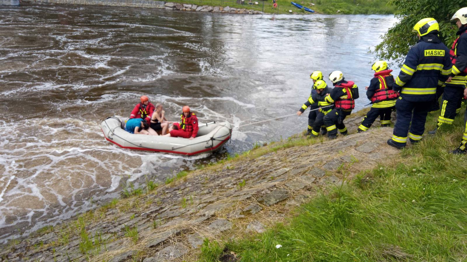 14_KVK_Na jezu se převrátila loď se čtyřmi vodáky_zachránění vodáci ve člunu HZS ČR a hasiči, kteři je přitahují pomocí lana na břeh.jpg