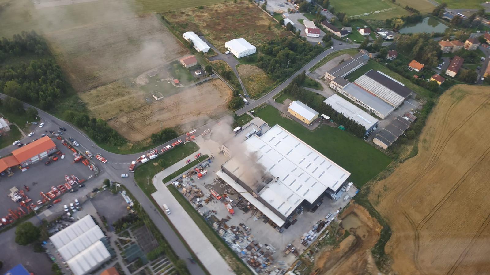 2_SČK_Požár hořovické lakovny_pohled z dronu na průmyslový areál a zasahující hasičskou techniku.jpg