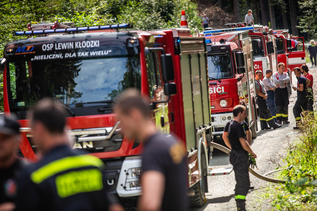 KHK_cvičení_společný zásah českých a polských hasičů při lesním požáru pohled na hasičské stříkačky a hasiče diskutující mezi sebou.jpg